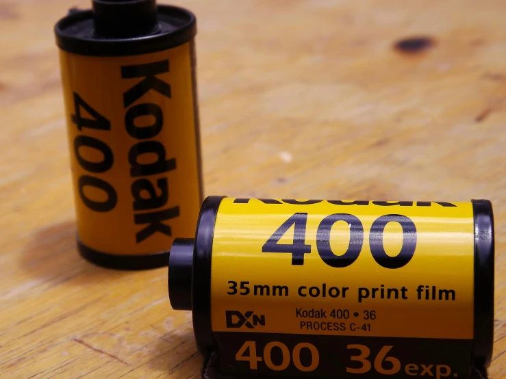 a roll of film sitting on top of a wooden table, a picture, by Adam Rex, kodak color, medium format, color footage