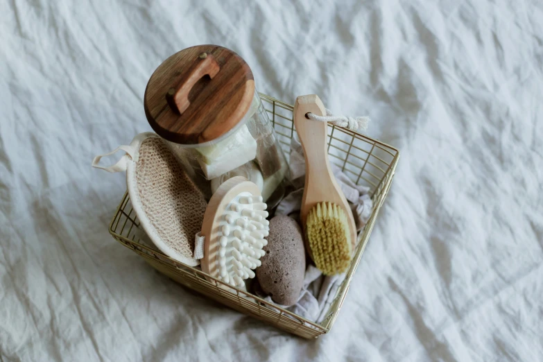 a basket filled with items sitting on top of a bed, unsplash, dry brushing, clean face and body skin, gold, brown