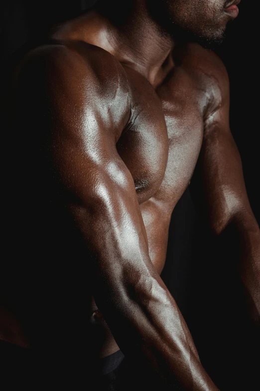 a man flexing his muscles against a black background, an album cover, by Alexander Mann, hyperrealism, with brown skin, upper body close up, smooth curves, leaked photo