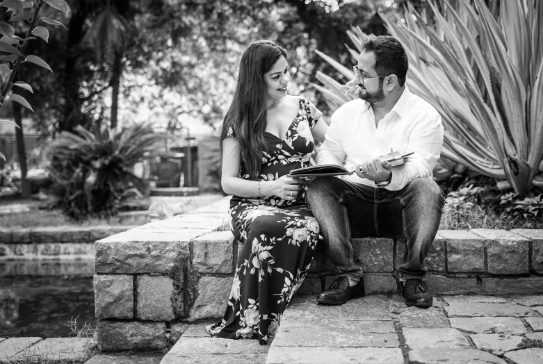 a man and a woman sitting on a stone bench, a black and white photo, by Luis Molinari, pexels, happening, reading the book about love, 💋 💄 👠 👗, pregnancy, portrait pose