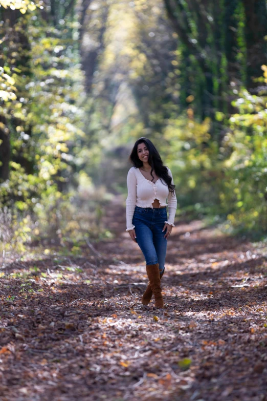 a woman walking down a path in the woods, white shirt and blue jeans, zenra taliyah, wears brown boots, 5 0 0 px models