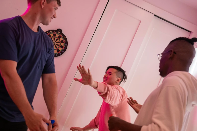 a couple of men standing next to each other, happening, brightly lit pink room, playing games, lee griggs and jason chan, charli bowater and artgeem