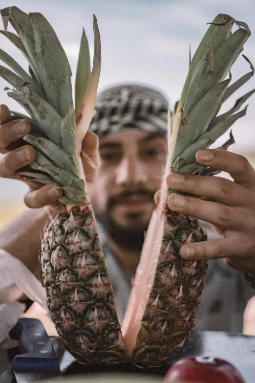 a close up of a person holding a pineapple, real life photo of a syrian man, behind the scenes, uncrop, arabic