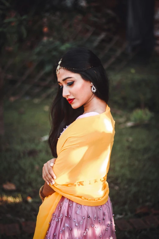 a woman in a yellow top and purple skirt, by Max Dauthendey, pexels contest winner, hurufiyya, long hair shawl, wearing gold jewellery, square, profile image