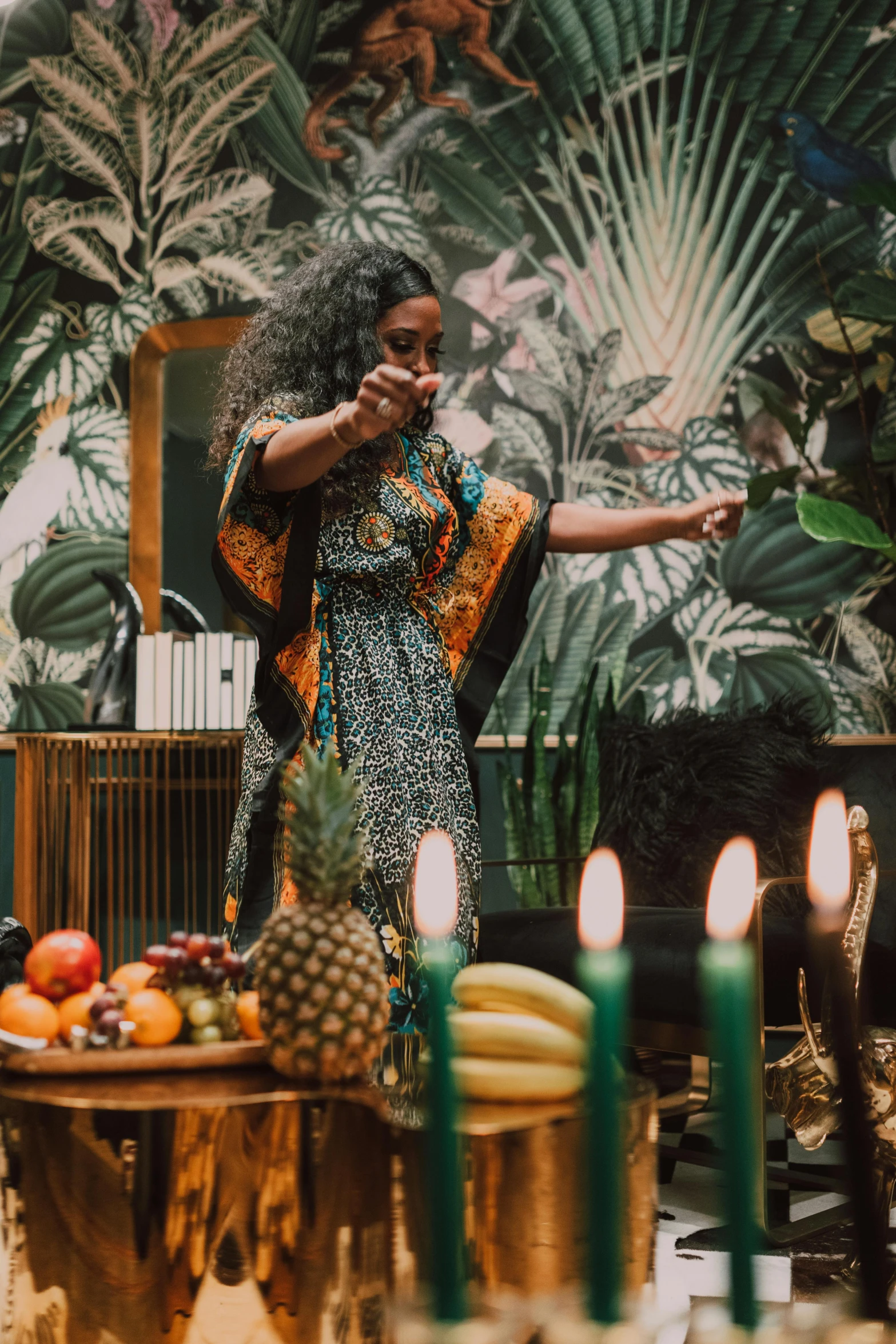 a woman standing in front of a table filled with fruit, an album cover, pexels contest winner, african ameera al taweel, holding a torch, elegant tropical prints, event photography