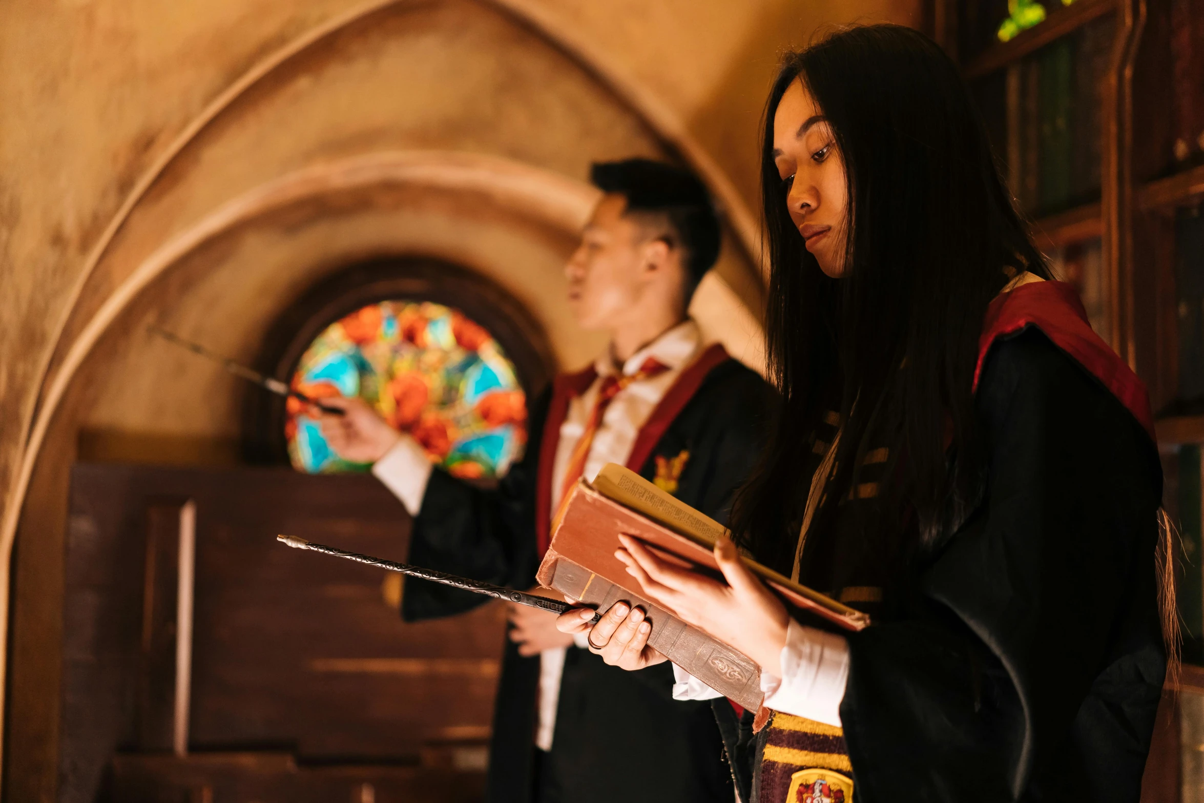 a couple of people that are standing in a room, a photo, pexels contest winner, academic art, wearing hogwarts!!! robes!!!, scene from church, louise zhang, wearing cross on robe