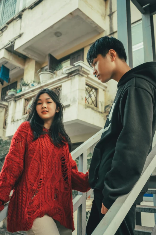 a man and a woman walking down a set of stairs, trending on pexels, realism, asian girl, sweater, wearing red, teenage boy