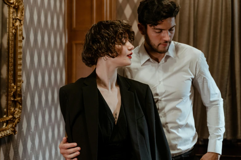 a man and a woman standing next to each other, an album cover, by Emma Andijewska, pexels contest winner, renaissance, wearing causal black suits, riccardo scamarcio, man grabbing a womans waist, [ theatrical ]