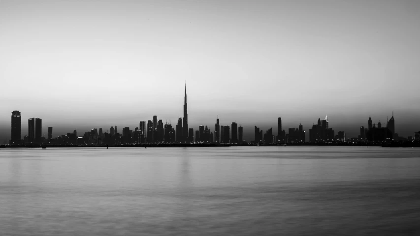 a black and white photo of a city skyline, a black and white photo, pexels contest winner, hurufiyya, humid evening, body of water, middle east, minimalistic art