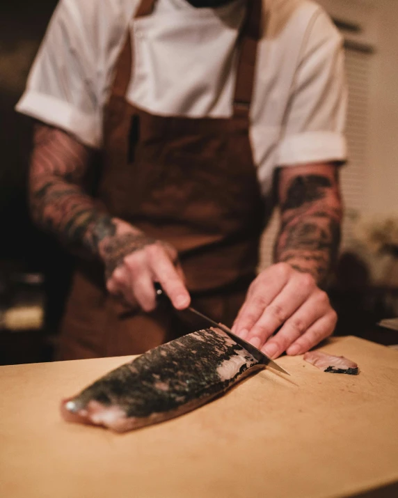 a person cutting a fish on a cutting board, by Jessie Alexandra Dick, lachlan bailey, tattooed, fine dining, thumbnail