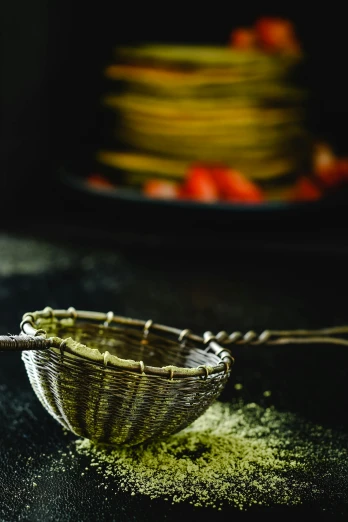 a bowl filled with green powder next to a plate of strawberries, a still life, unsplash, hurufiyya, woodfired, straw, mexico, detail shot