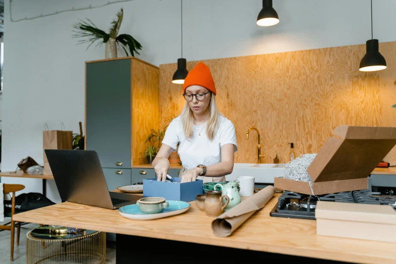 a woman sitting at a table working on a laptop, by Julia Pishtar, pexels contest winner, delivering parsel box, quirky shops, sydney hanson, decoration