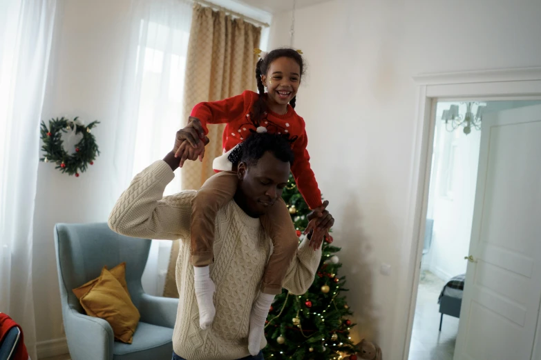 a man and a little girl standing in front of a christmas tree, pexels contest winner, hurufiyya, an ahoge stands up on her head, avatar image, african american, apartment