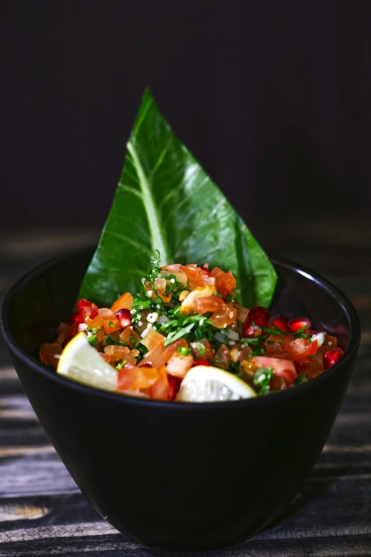 a close up of a bowl of food on a table, by Tom Bonson, tropical leaves, dubai, salsa vendor, salmon