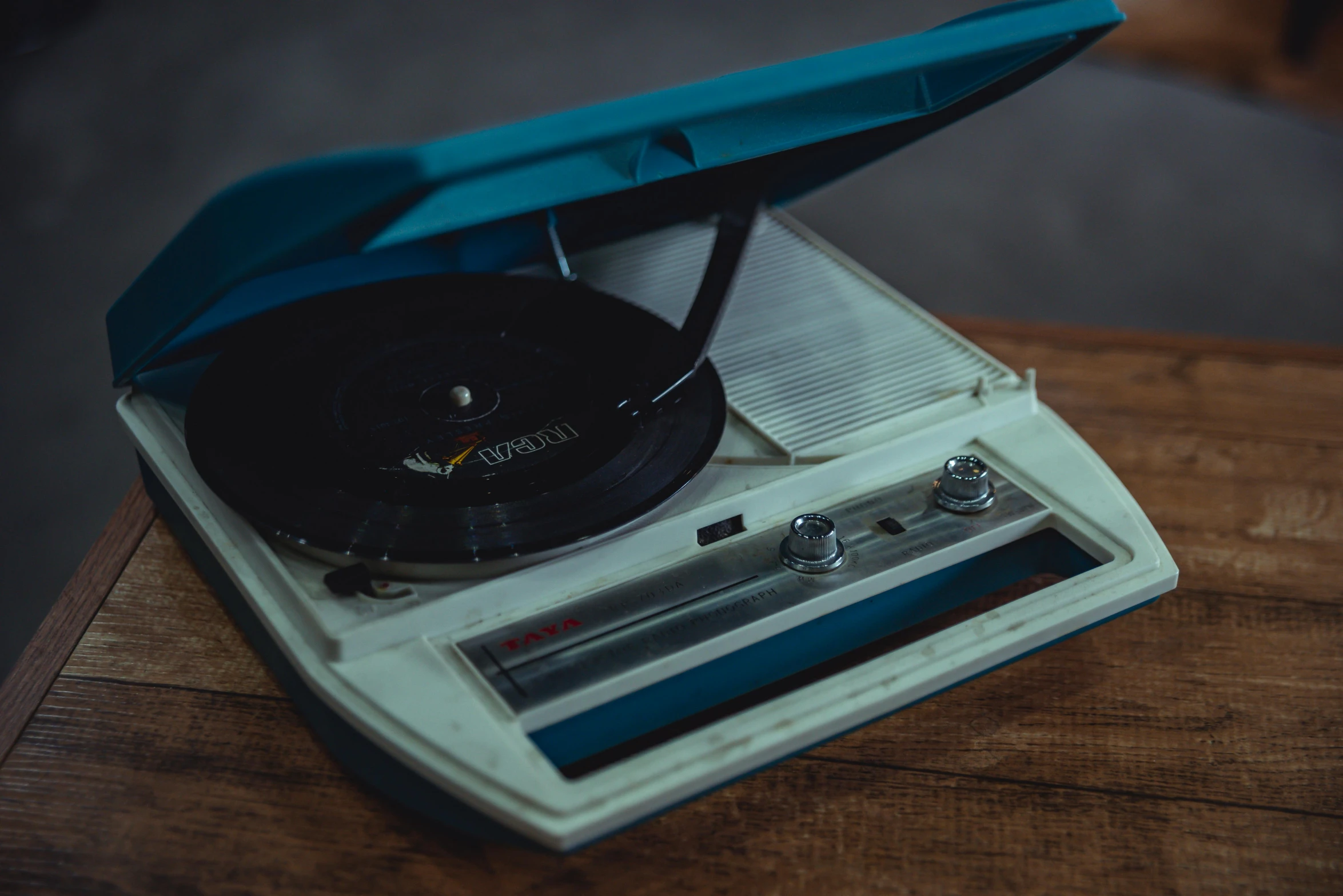 a record player sitting on top of a wooden table, an album cover, inspired by Elsa Bleda, trending on unsplash, thumbnail, blue, 1960s color photograph, fan favorite