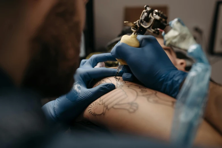 a man getting a tattoo on his arm, a tattoo, by Adam Marczyński, trending on pexels, hyperrealism, blue ink, 2717433015, sailor jerry tattoo flash, neon tattoo