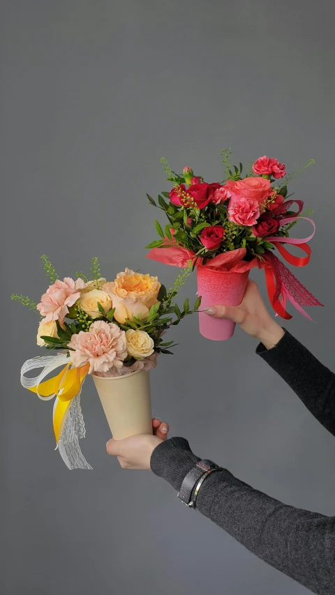 a woman holding a bunch of flowers in a vase, big and small, peach and goma style, wrapped in flowers, middle shot