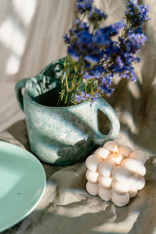 a close up of a plate of food on a table, a still life, inspired by Art Green, renaissance, turquoise color scheme, lilacs, ceramic pot, green pupills