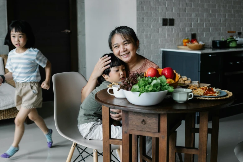 a woman sitting at a table with two children, pexels contest winner, ingredients on the table, darren quach, husband wife and son, head to waist