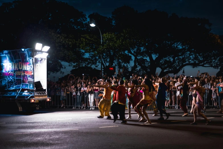 a group of people walking down a street at night, by Liza Donnelly, pexels contest winner, happening, performing on stage, kombi, pride parade, panoramic shot