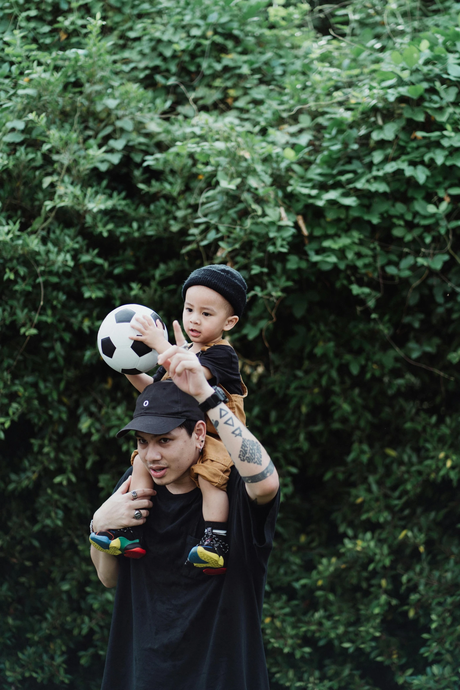 a man carrying a child on his shoulders, inspired by Eddie Mendoza, pexels contest winner, holding a football, vsco, bowater charlie and brom gerald, bao pham