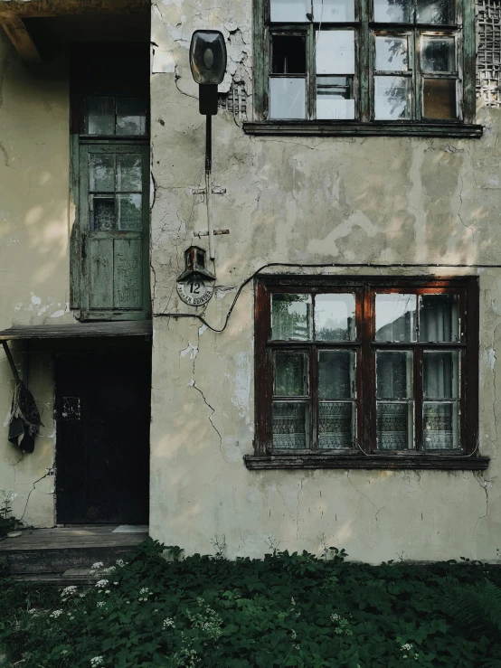 a couple of windows sitting on the side of a building, an album cover, inspired by Elsa Bleda, pexels contest winner, abandoned polish mansion, фото девушка курит, low quality photo, exterior photo