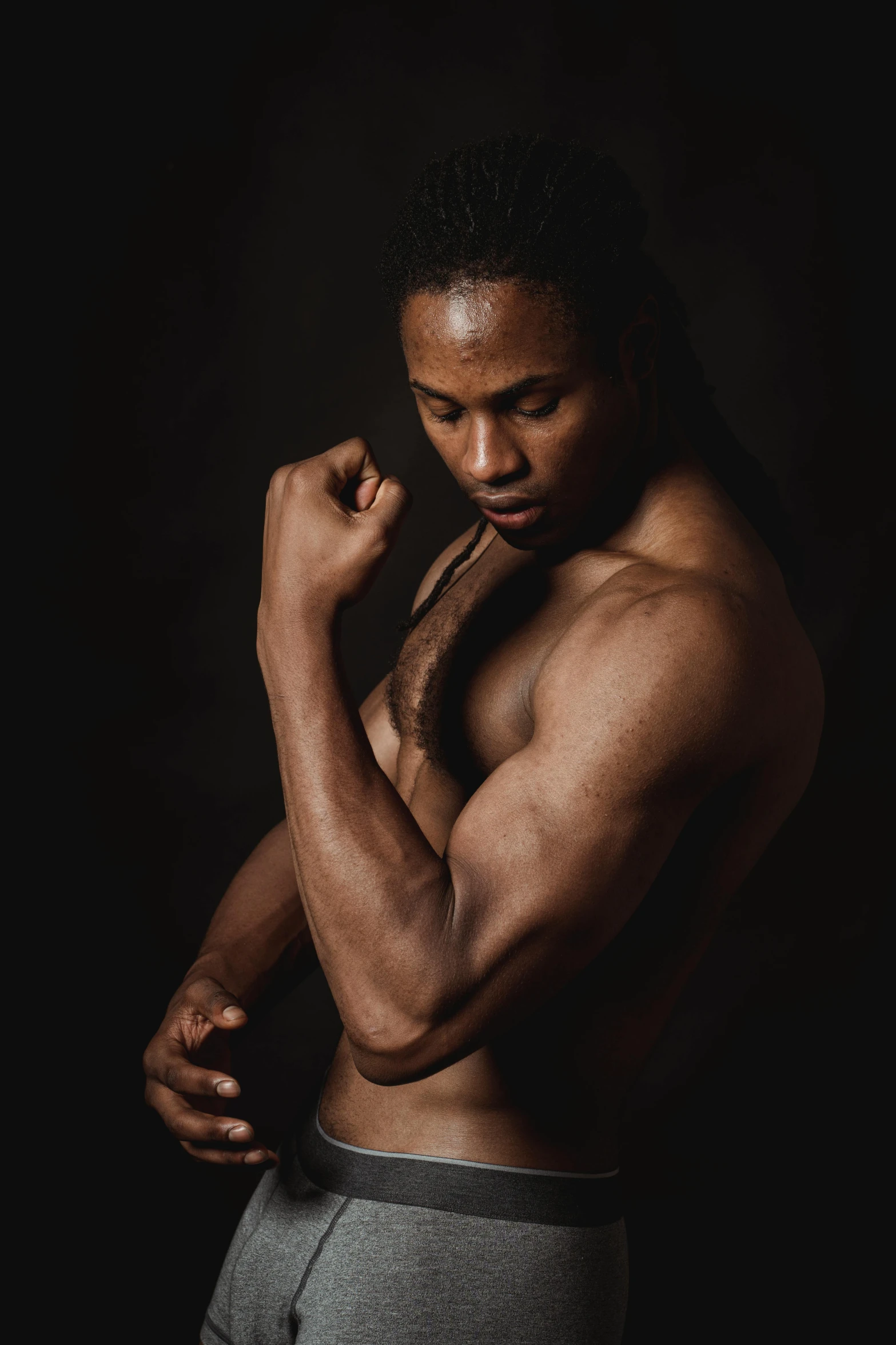 a man flexing his muscles against a black background, inspired by Terrell James, renaissance, light-brown skin, alana fletcher, staring seductively, a young man