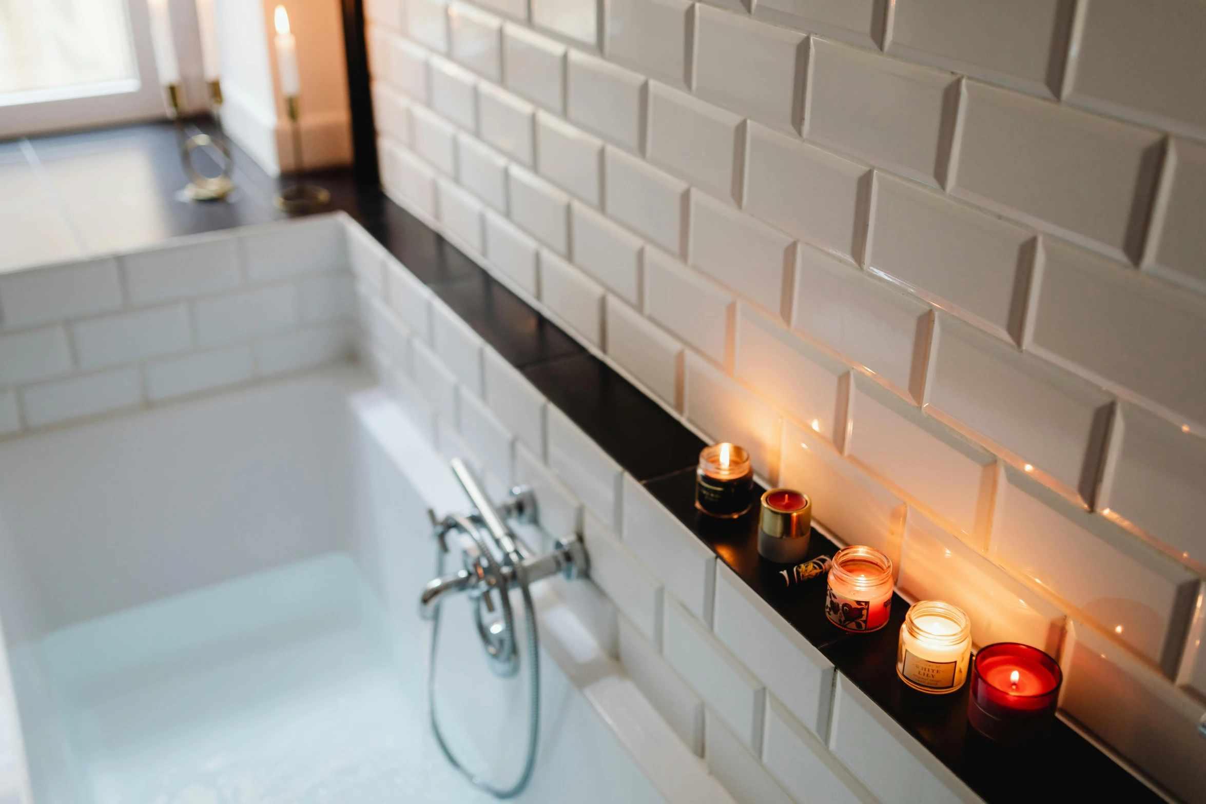 a bath tub filled with candles next to a window, inspired by Elsa Bleda, trending on pexels, tiled, wide high angle view, in a row, ivory and black marble