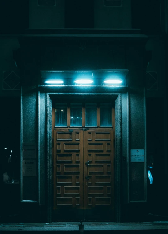 a couple of wooden doors sitting on the side of a building, inspired by Elsa Bleda, pexels contest winner, dark teal lighting, about to enter doorframe, technological lights, brown and cyan blue color scheme