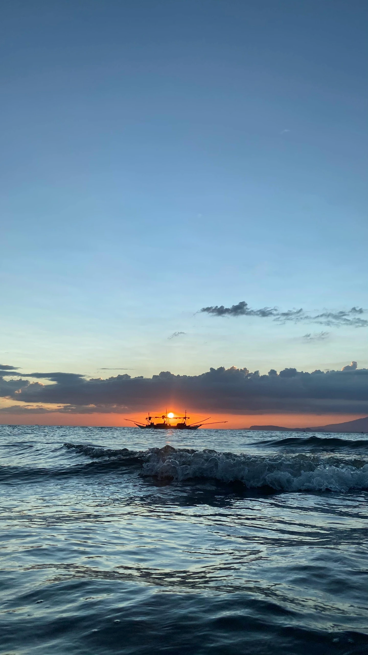 a large body of water with a sunset in the background, philippines, in a beachfront environment, boat, low quality photo