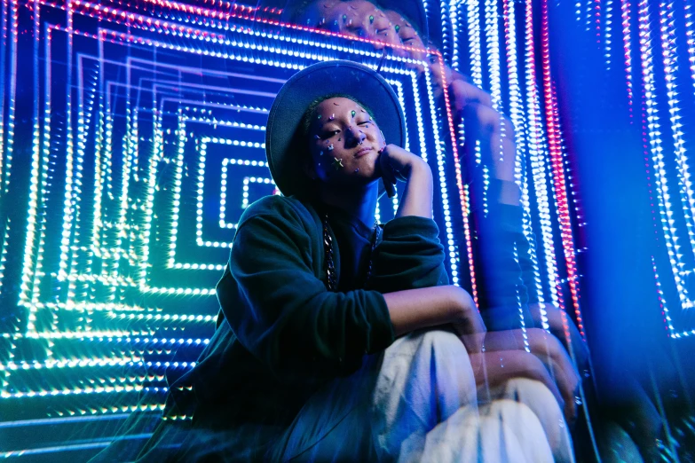 a man sitting on the ground talking on a cell phone, a hologram, by Julia Pishtar, maximalism, with neon lights, portrait willow smith, shot at night with studio lights, geometric backdrop; led