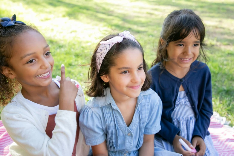 three little girls sitting next to each other on a blanket, pexels contest winner, at a park, 15081959 21121991 01012000 4k, handsome girl, varying ethnicities