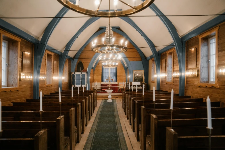 a church filled with wooden pews and a chandelier, unsplash, art nouveau, inside of a cabin, brightly lit blue room, ribbon chapel, listing image