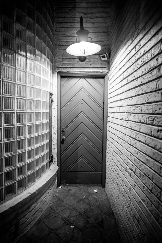 a black and white photo of a door in a brick building, inspired by Brassaï, light and space, cyberpunk basement, f / 1. 9 6. 8 1 mm iso 4 0, curved, art deco interior