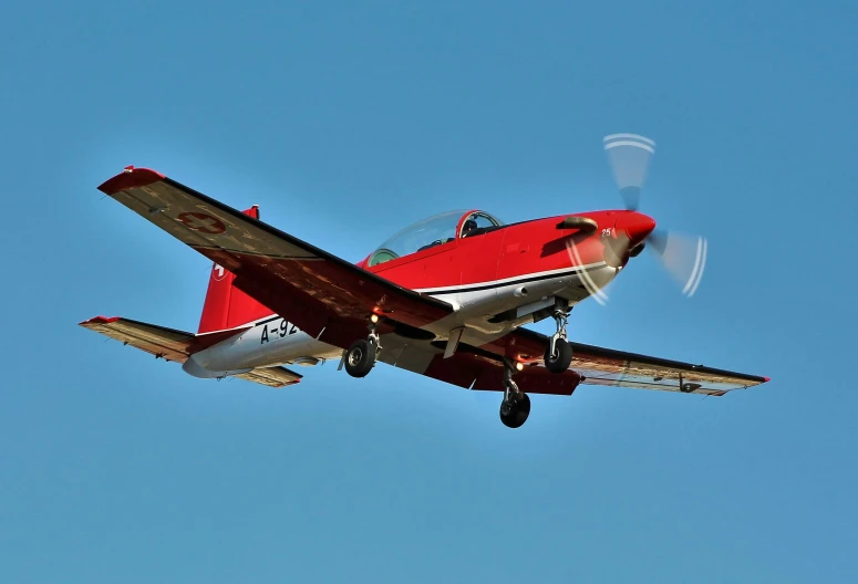 a red and white plane flying through a blue sky, slide show, manuka, on the ground, turbo