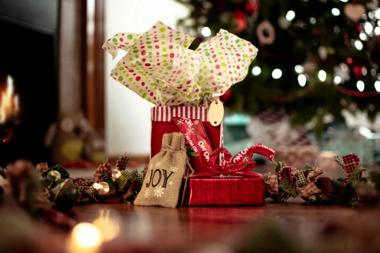 a present sitting on top of a table next to a christmas tree, pexels, dressed in red paper bags, polka dot, a green, rustic