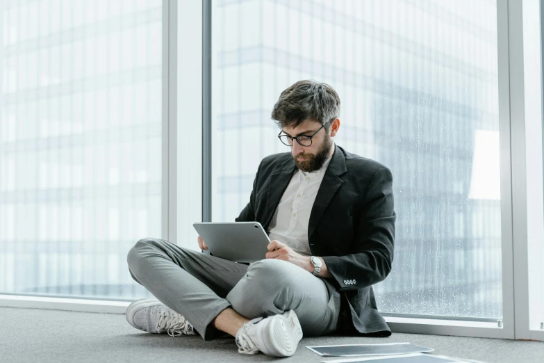 a man sitting on the floor using a tablet, pexels contest winner, office clothes, avatar image, lachlan bailey, nerdy appearance