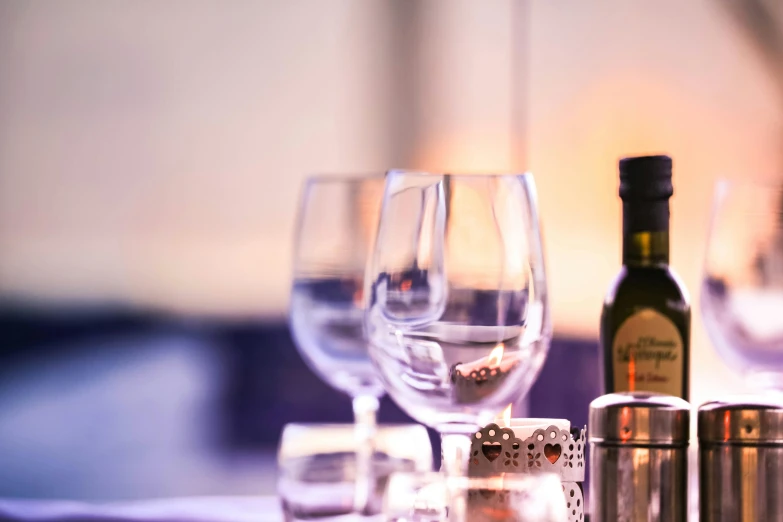 a table with wine glasses, salt and pepper shakers, unsplash, michelin starred restaurant, olive oil, purple ambient light, at golden hour