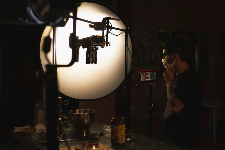 a woman standing in front of a camera in a dark room, food stylist, production ig, production still, photoshoot for skincare brand