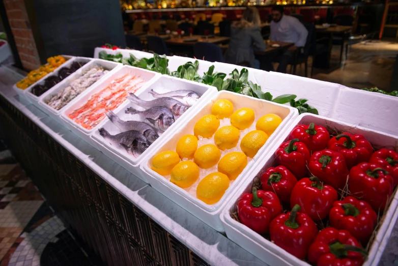 a counter topped with lots of different types of fruits and vegetables, fish in the background, evening, mezzanine, thumbnail