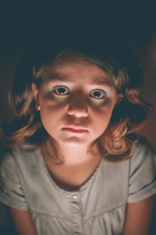 a close up of a person looking at a cell phone, a portrait, inspired by Gottfried Helnwein, pexels, the girl is scared, young child, middle of the night, looking up at camera