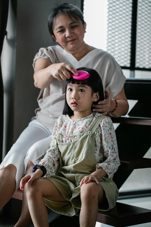 a woman combing a little girl's hair, by Kanbun Master, pexels contest winner, bowl haircut, singapore, pink wispy hair, anomalisa