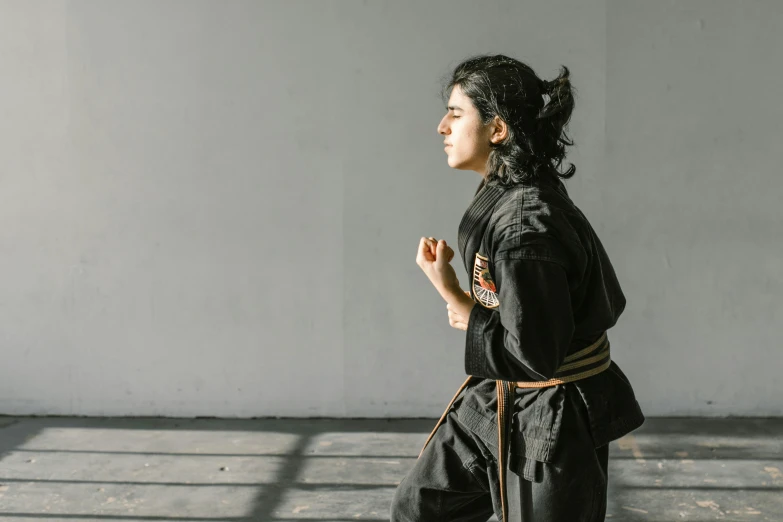 a woman in a black outfit standing in a room, inspired by Kanō Hōgai, pexels contest winner, figuration libre, doing martial arts, profile image, wearing a track suit, girl wearing uniform