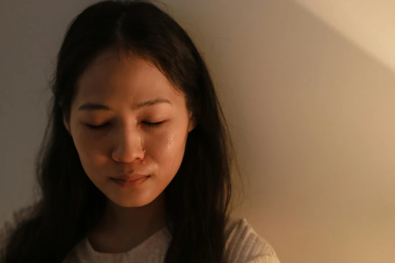 a close up of a person holding a cell phone, inspired by Zhang Xiaogang, pexels contest winner, hyperrealism, woman crying, soft evening lighting, caring fatherly wide forehead, young asian woman