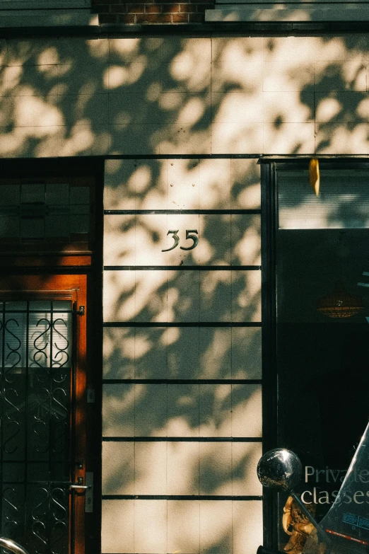 a motorcycle parked in front of a building, pexels contest winner, modernism, dappled afternoon sunlight, numerology, new york streets, doorway