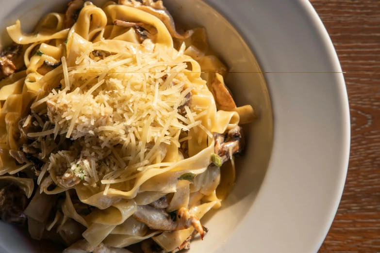 a close up of a bowl of food on a table, renaissance, pasta, big horn, grey, caramel