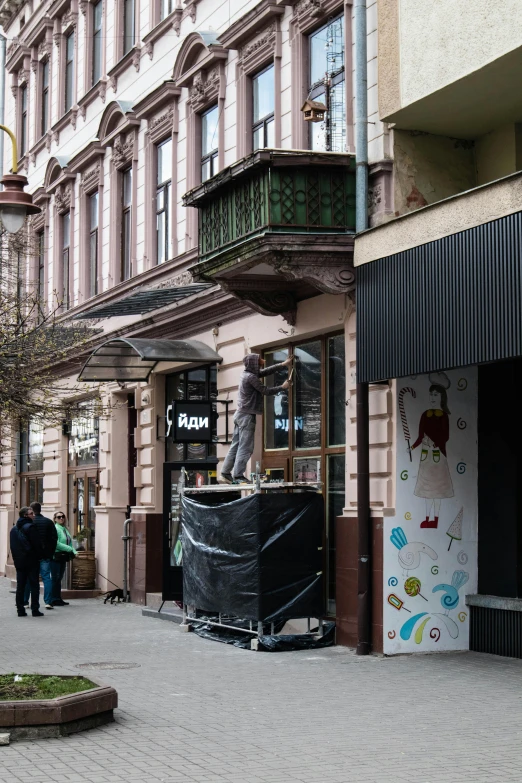 a man riding a skateboard down a street next to tall buildings, by Julia Pishtar, temporary art, lviv historic centre, shop front, spaceship being repaired, 000 — википедия