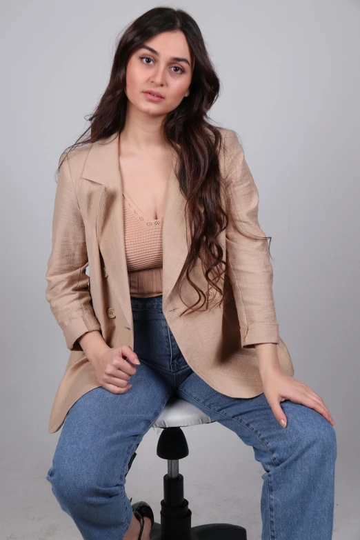 a beautiful young woman sitting on top of a chair, an album cover, by Nina Hamnett, trending on pexels, renaissance, tan suit, cropped shirt with jacket, tan vest, casual pose