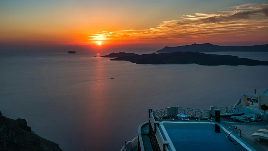 a view of the sun setting over a body of water, by Julian Allen, pexels contest winner, santorini, luxurious environment, extreme panoramic, high view