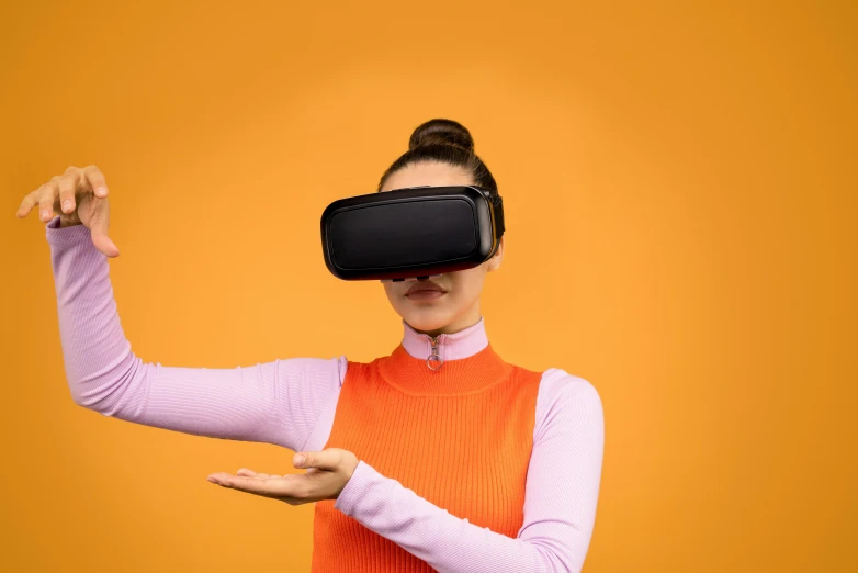 a woman wearing a virtual reality headset, by Julia Pishtar, hypermodernism, in front of an orange background, handheld, black, ergonomic